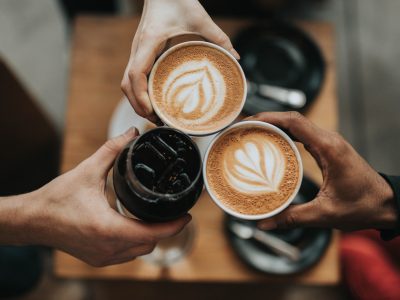 three person holding beverage cups